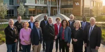 Veterans smiling and shaking hands near a modern VA facility, representing new benefits.